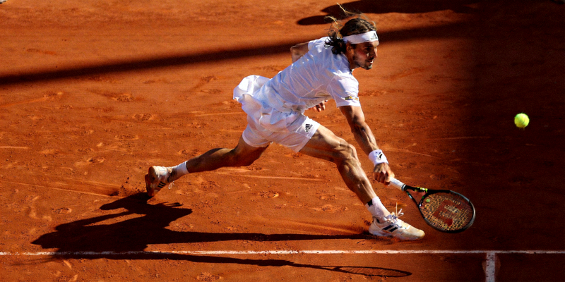 网球运动员在红土场上奋力奔跑救球的动态画面